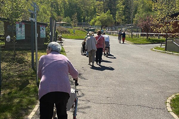 Mit dem Rollator auf dem Weg, Berge im Hintergrund