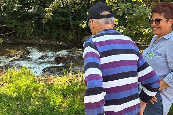 Ein Bewohner und eine Mitarbeiterin am Bach